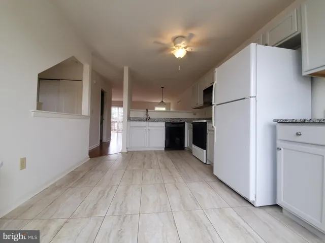 a view of a kitchen with a sink and refrigerator