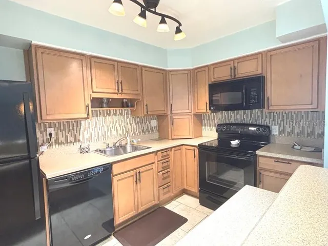 a kitchen with a sink stove top oven and refrigerator