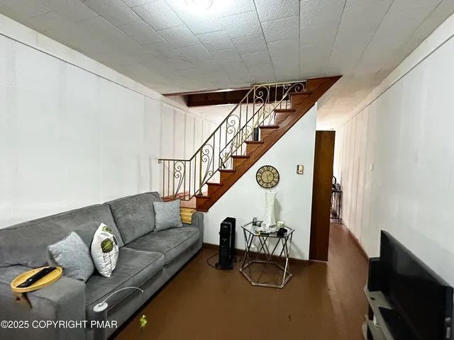 a living room with furniture gym equipment and a chandelier