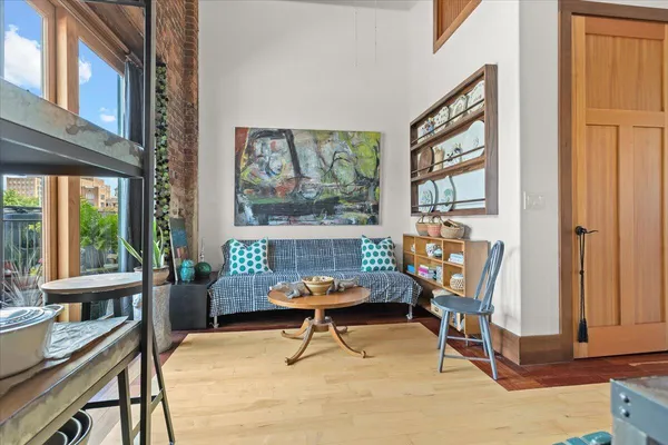 a living room with furniture a large window and a potted plant