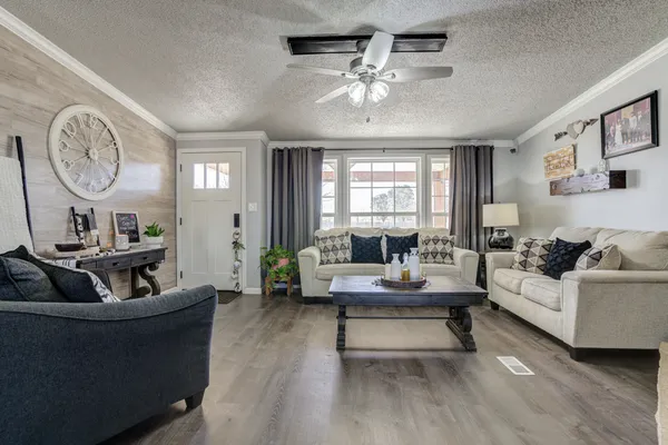 a kitchen with stainless steel appliances granite countertop a stove top oven a sink dishwasher and white cabinets with wooden floor