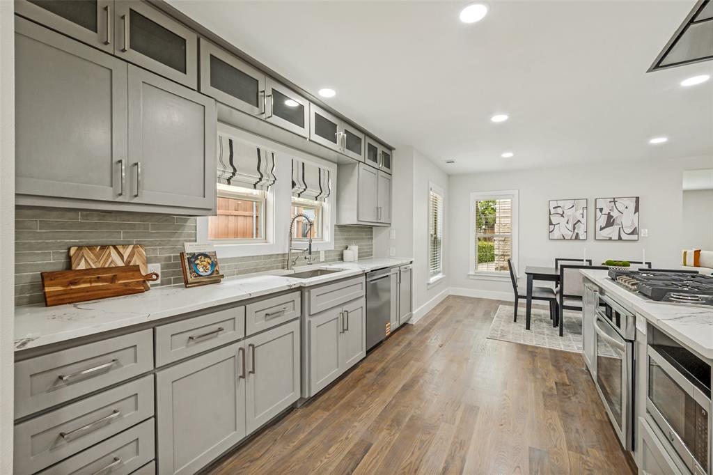 2006 Marydale Road Dallas, TX 75208 - Photo 17 of 40 Open-concept kitchen featuring gray cabinetry, stainless steel appliances, wood-finish flooring, recessed lighting, and a white countertop with an undermount sink