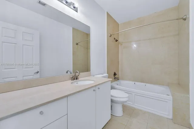 a bathroom with a granite countertop sink a toilet and a bathtub