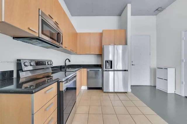 a kitchen with a stove a refrigerator and cabinets