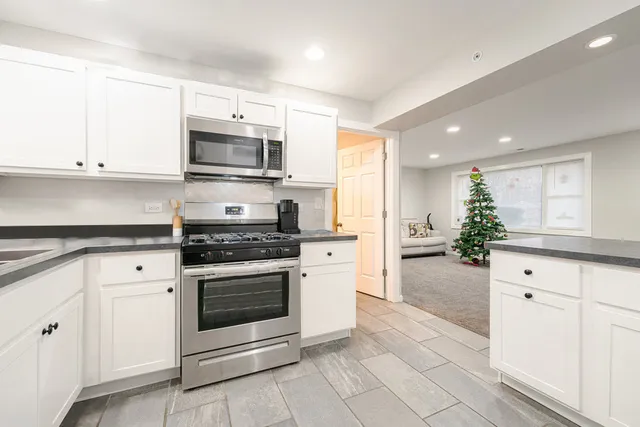 a kitchen with stainless steel appliances white cabinets and stove