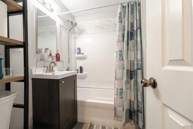 a bathroom with a sink a mirror a vanity and shower