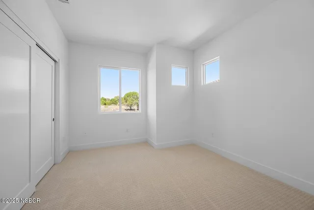 an empty room with windows and closet