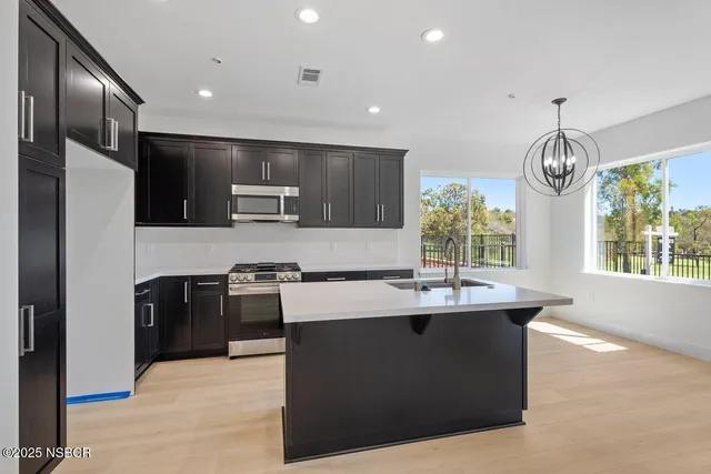 a kitchen with kitchen island sink stainless steel appliances and cabinets