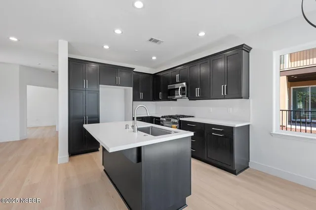 a kitchen with a sink stainless steel appliances and cabinets
