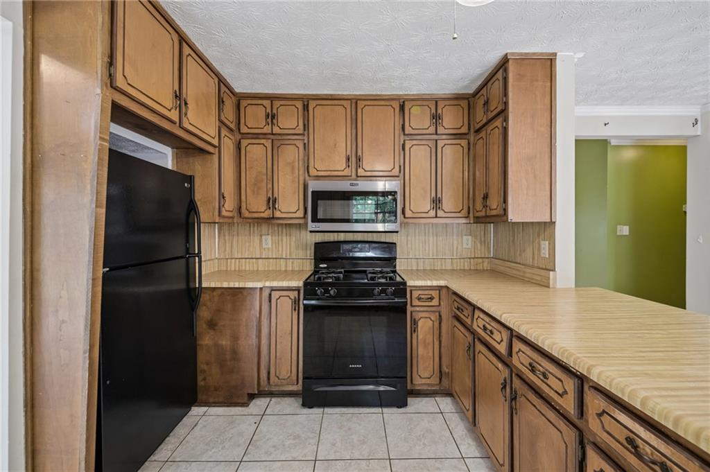 1318 Panhandle Way Hampton, GA 30228 - Photo 6 of 22 a kitchen with stainless steel appliances granite countertop a stove and a refrigerator