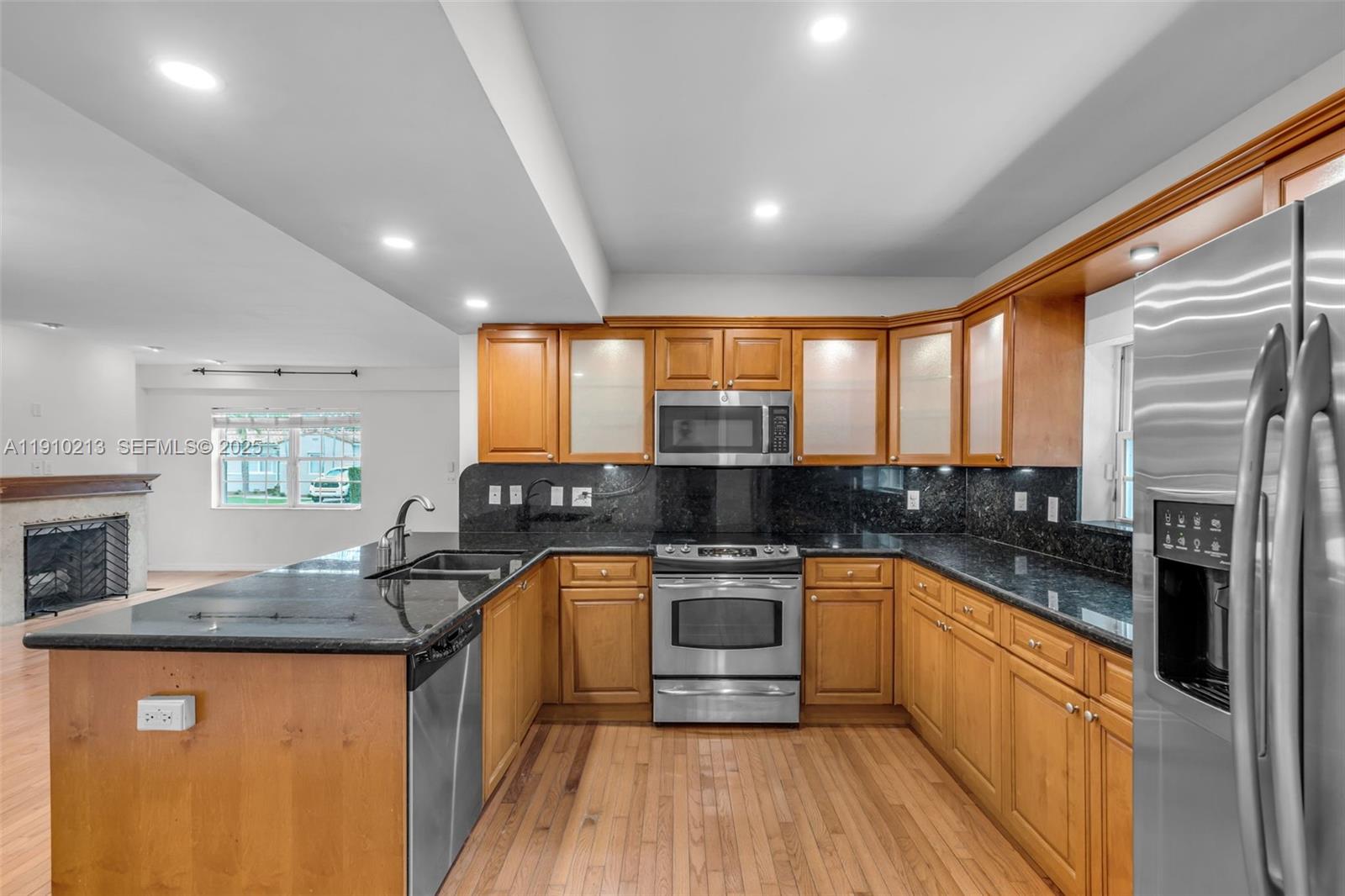 4416 Southwest 14th Street Miami, FL 33134 - Photo 11 of 33 a kitchen with stainless steel appliances granite countertop a sink a stove top oven a counter space and cabinets