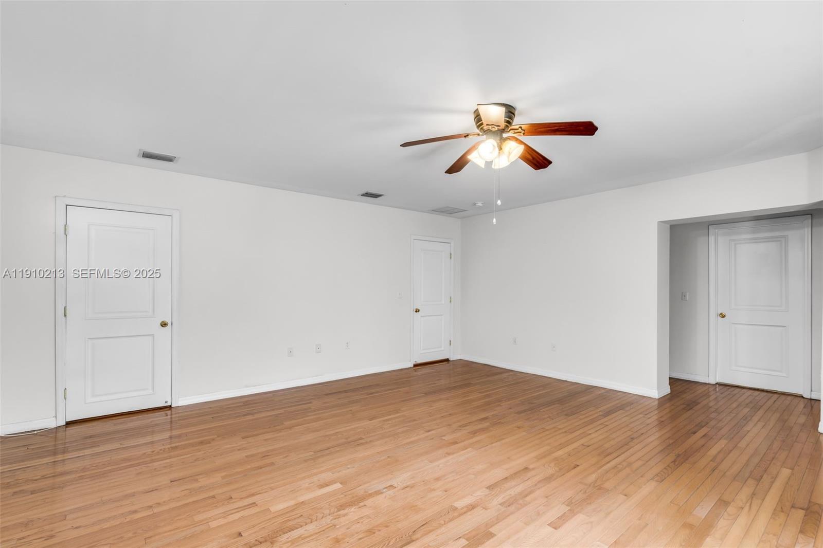 4416 Southwest 14th Street Miami, FL 33134 - Photo 13 of 33 a view of a room with wooden floor and a ceiling fan
