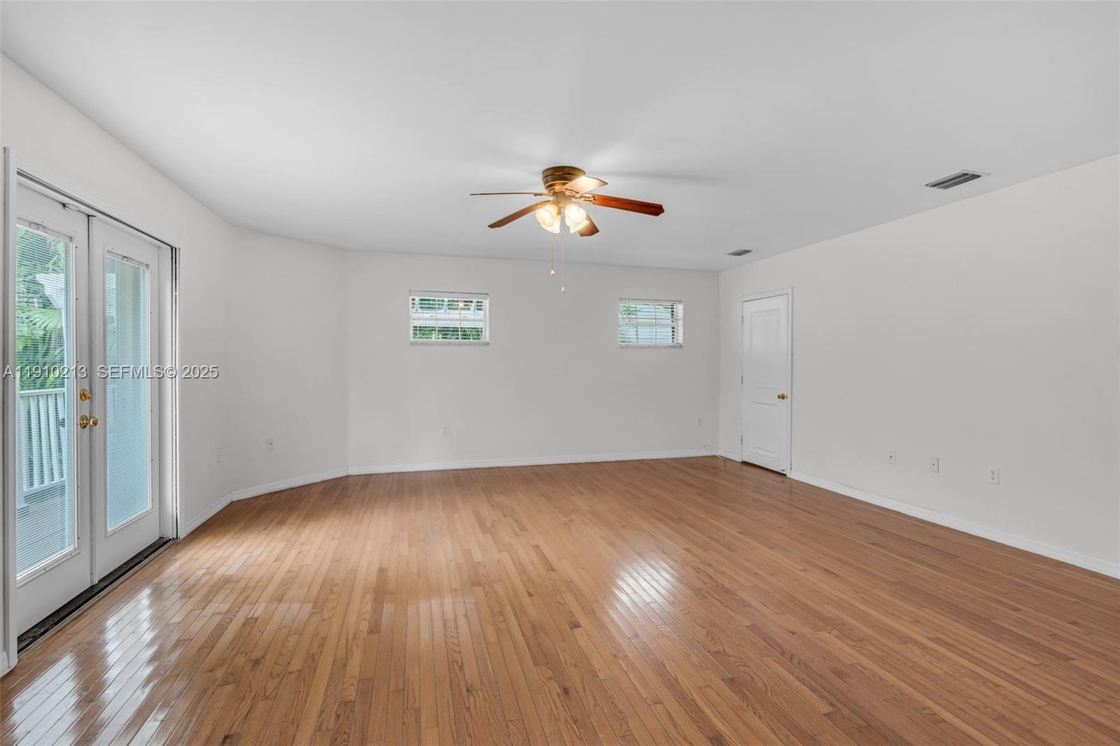 4416 Southwest 14th Street Miami, FL 33134 - Photo 14 of 33 an empty room with wooden floor ceiling fan and window