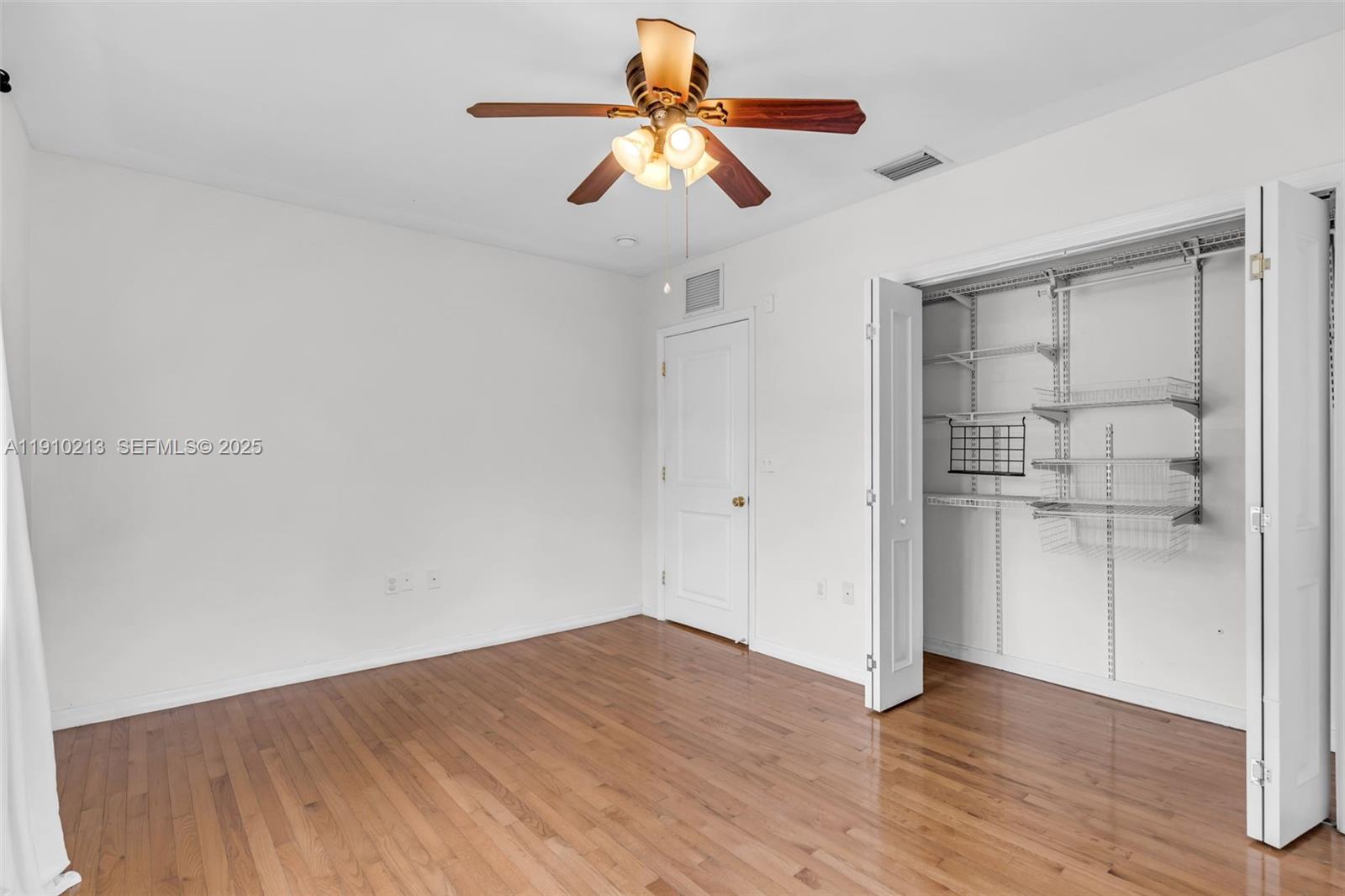 4416 Southwest 14th Street Miami, FL 33134 - Photo 19 of 33 a view of empty room with wooden floor and fan