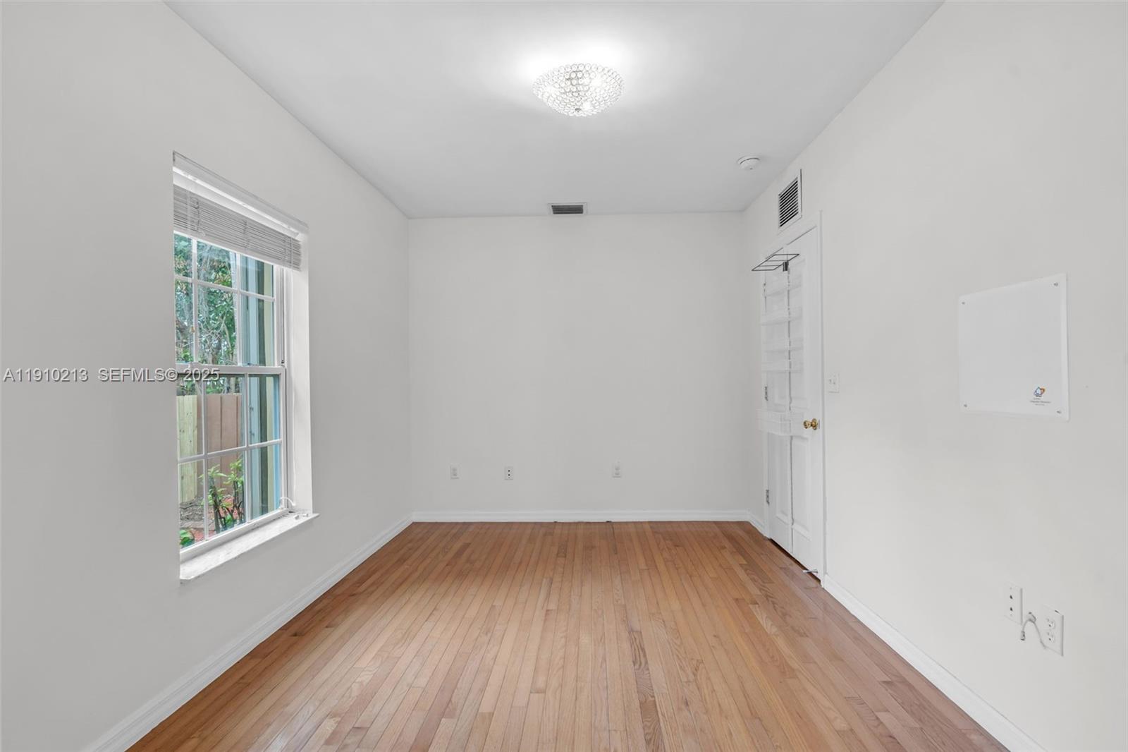 4416 Southwest 14th Street Miami, FL 33134 - Photo 20 of 33 an empty room with wooden floor and windows