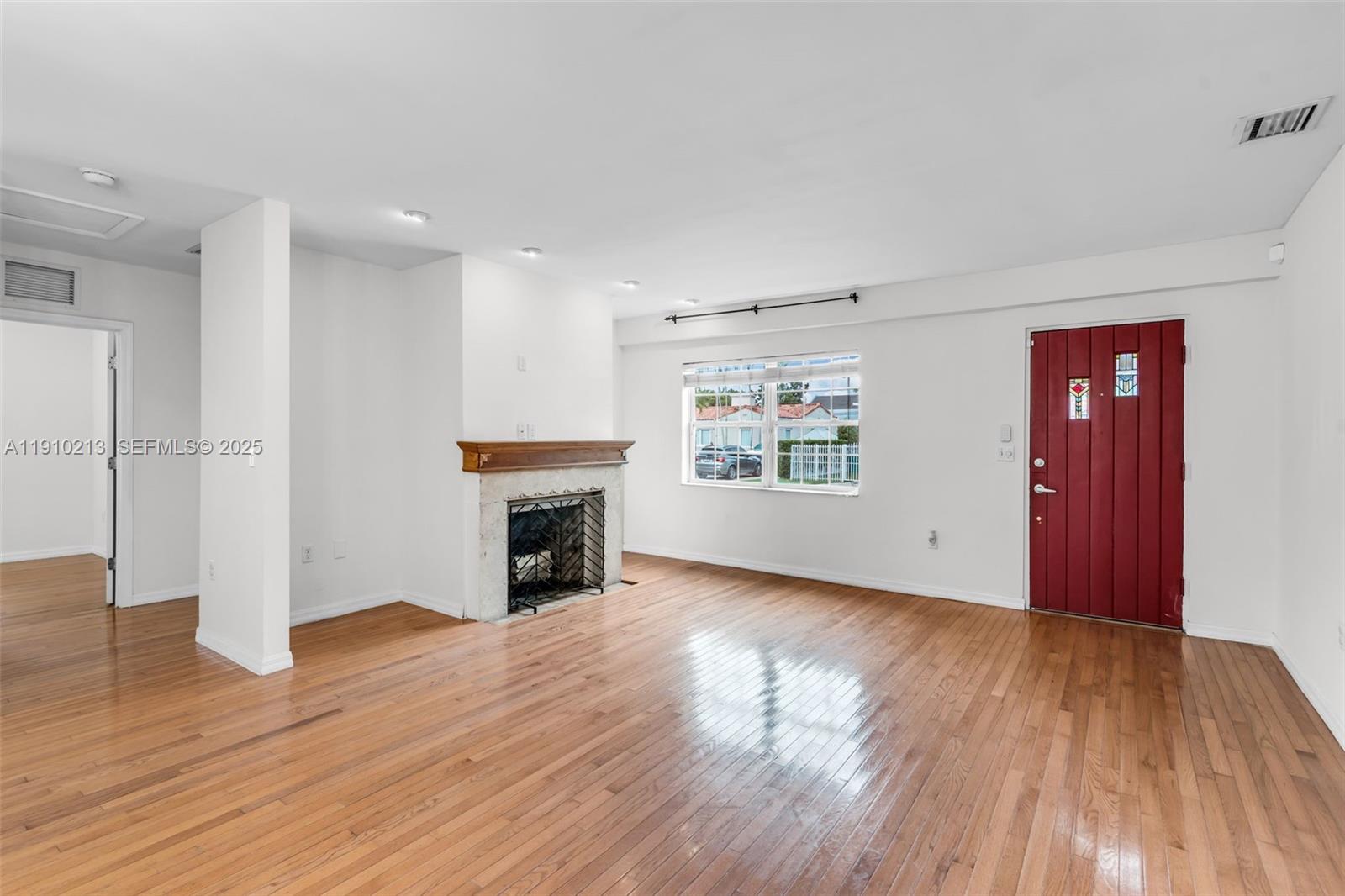 4416 Southwest 14th Street Miami, FL 33134 - Photo 6 of 33 an empty room with wooden floor fireplace and windows