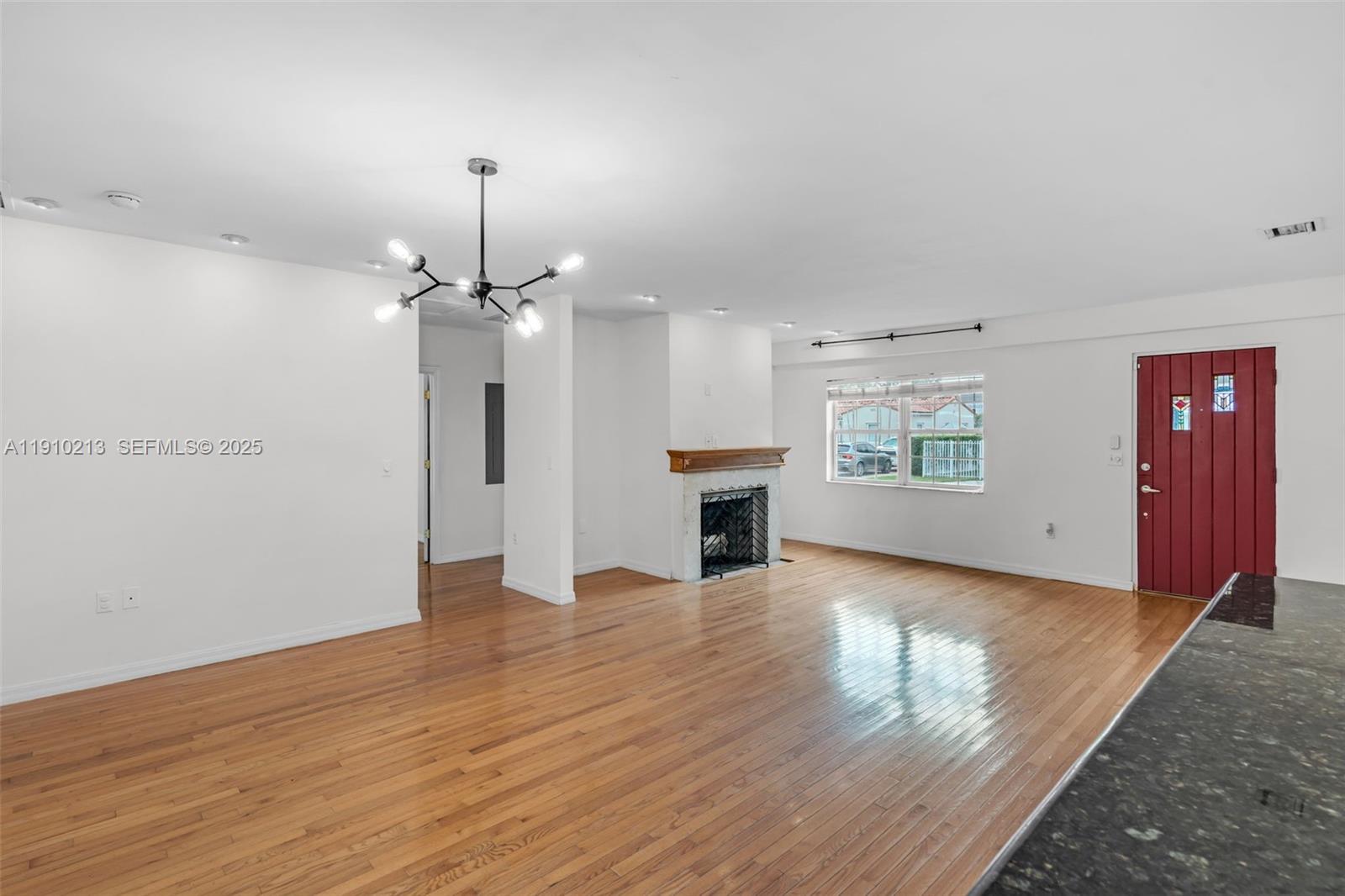 4416 Southwest 14th Street Miami, FL 33134 - Photo 9 of 33 an empty room with wooden floor fireplace and staircase