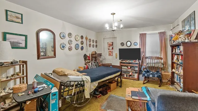 a view of a workspace with bookshelf and a window
