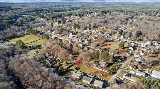 a view of a big house with wooden fence