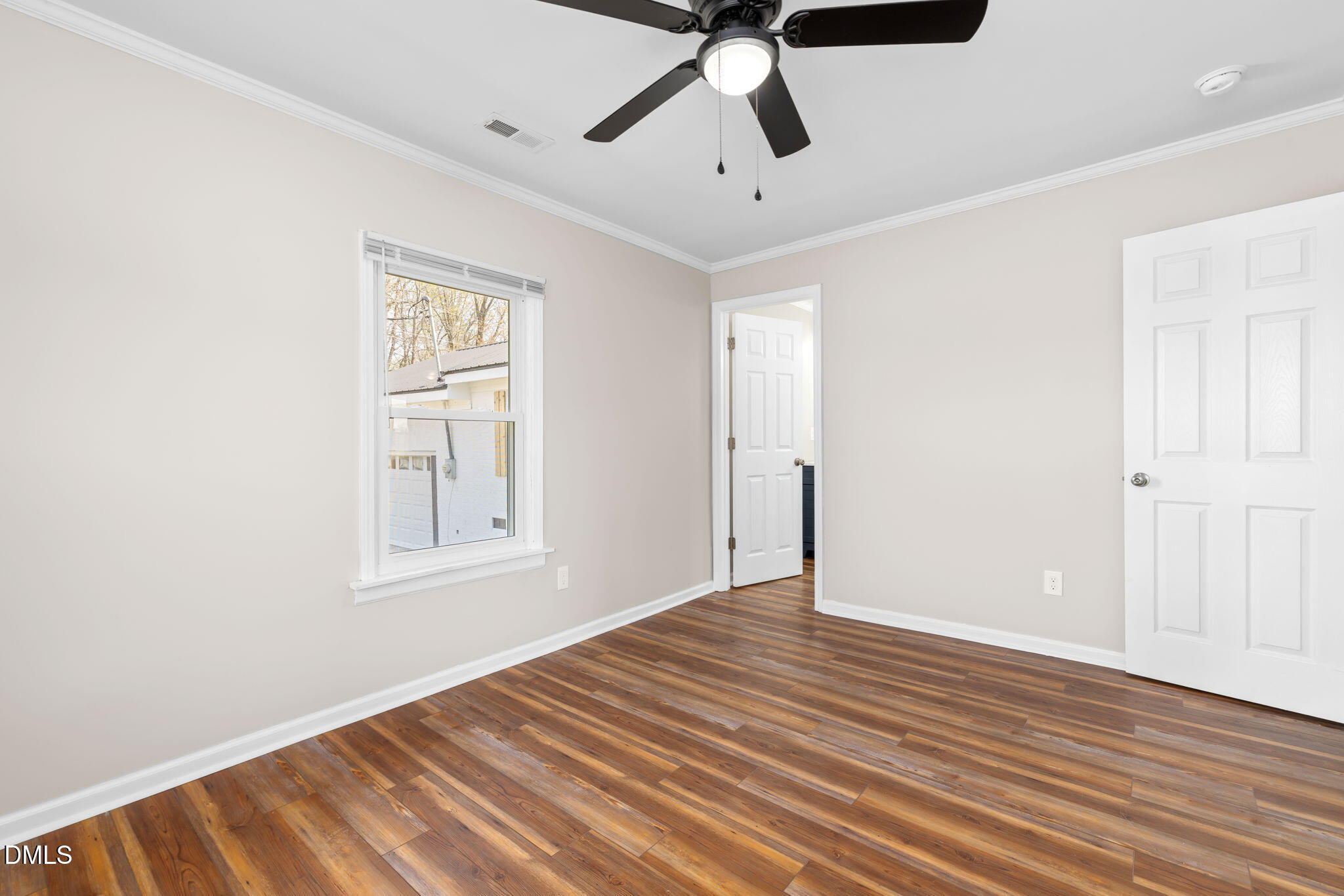 426 Rooker Dairy Road Norlina, NC 27563 - Photo 13 of 33 an empty room with wooden floor fan and windows