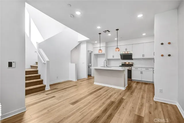 a large kitchen with stainless steel appliances kitchen island granite countertop a stove a sink and a refrigerator