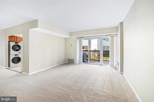 an empty room with windows and fireplace