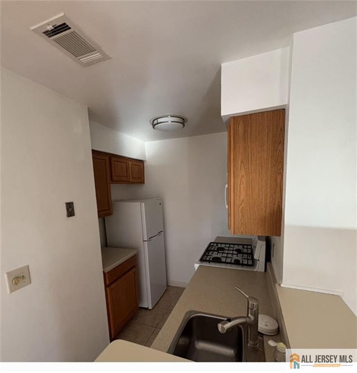 83 Crosspointe Drive, Unit 83 East Brunswick, NJ 08816 - Photo 5 of 11 a kitchen with stainless steel appliances a refrigerator and a stove