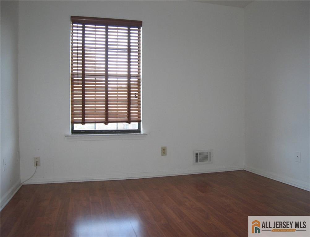 83 Crosspointe Drive, Unit 83 East Brunswick, NJ 08816 - Photo 7 of 11 an empty room with wooden floor and windows