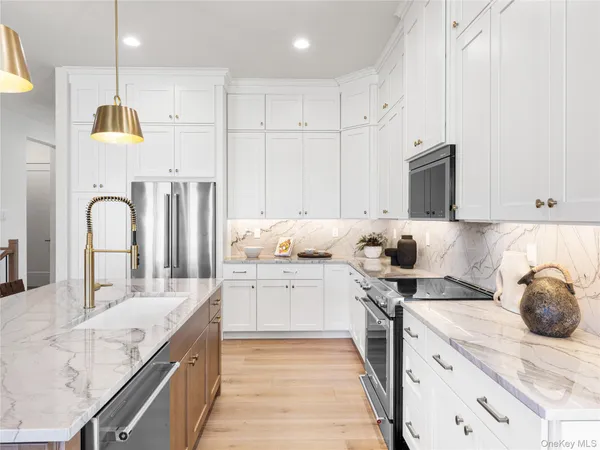 a kitchen with kitchen island granite countertop a sink a counter space appliances and cabinets