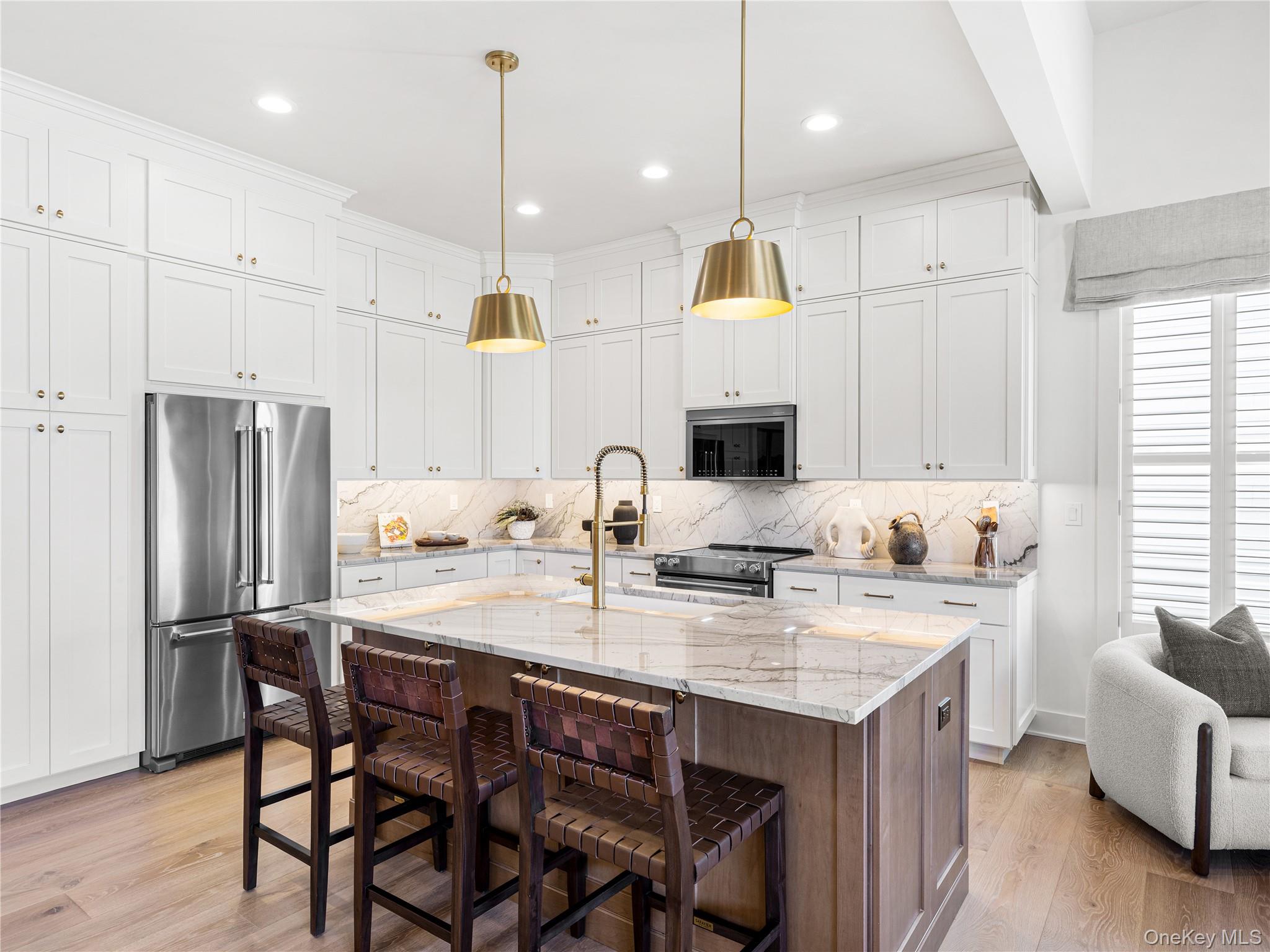 2075 Summit Loop, Unit 101 Carmel, NY 10512 - Photo 6 of 17 a kitchen with a refrigerator a stove a sink and a dining table with wooden floor