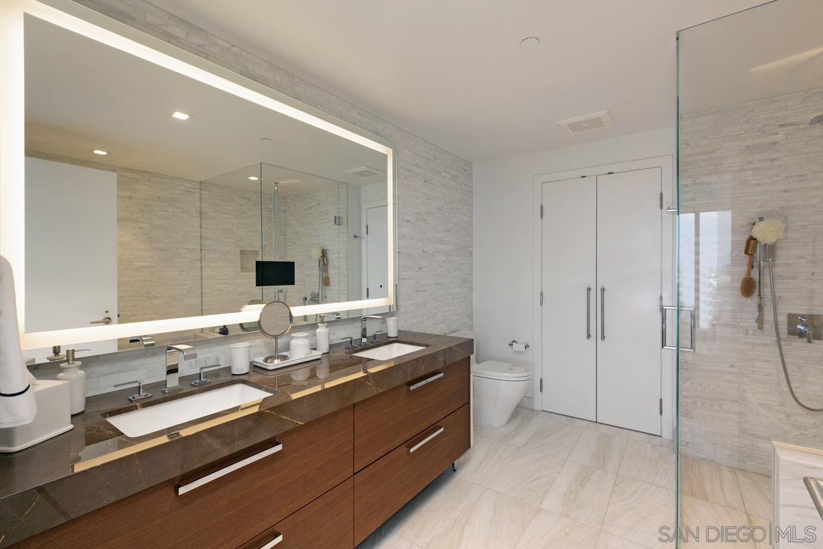 888 E Street, Unit 3501 San Diego, CA 92101 - Photo 18 of 46 a bathroom with a double vanity sink toilet and shower
