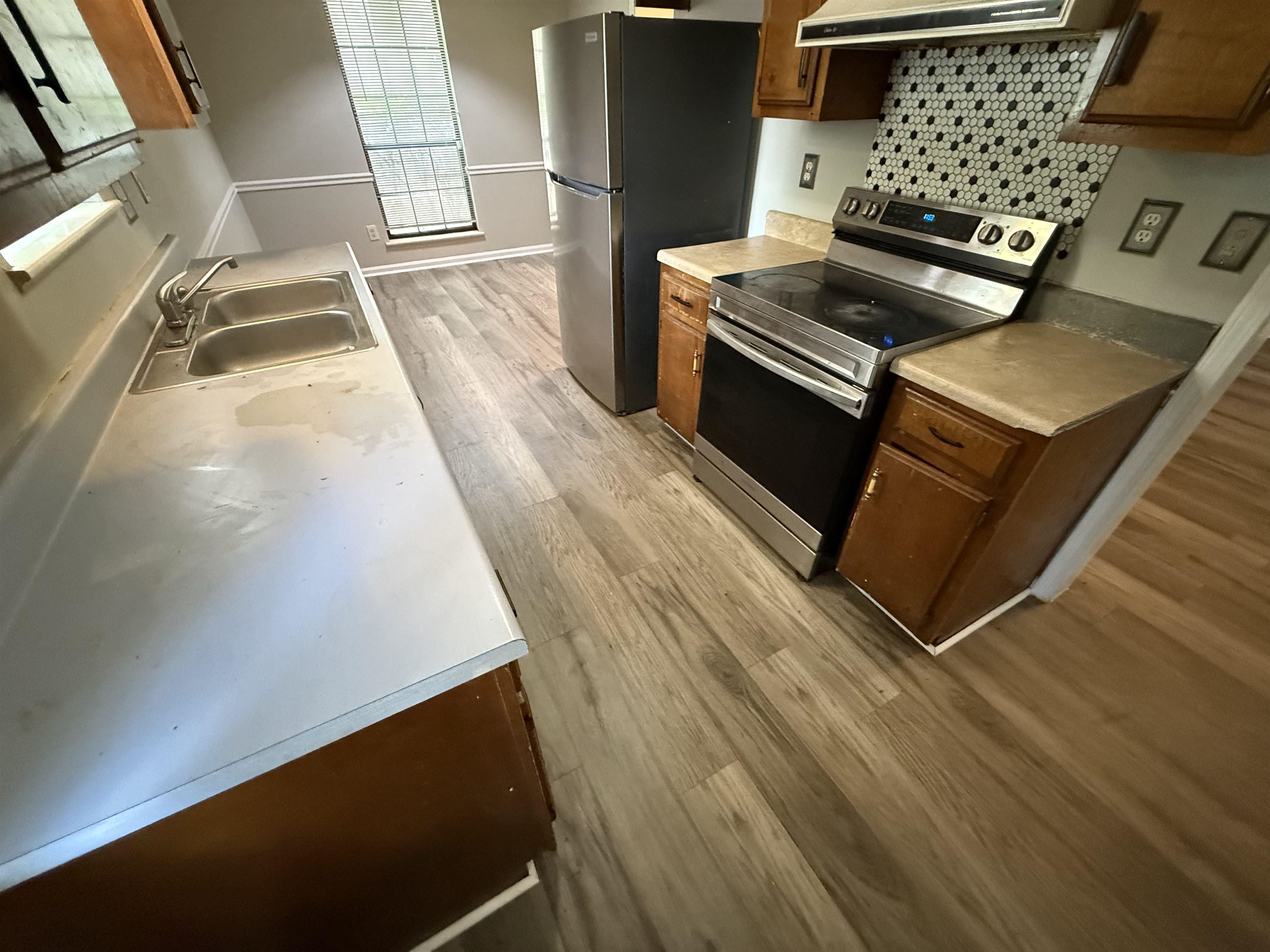 6420 Saginaw Road Memphis, TN 38134 - Photo 8 of 38 Kitchen featuring wood-finish flooring, a stainless steel electric range, a mosaic tile backsplash, a double basin sink, and a refrigerator