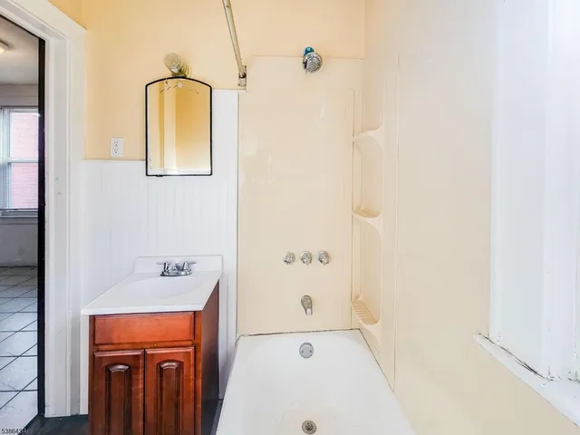 a bathroom with a tub sink and mirror