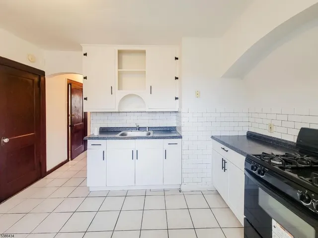a kitchen with white cabinets and appliances