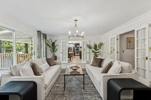 a living room with furniture and a chandelier