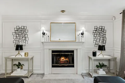 a living room with furniture a fireplace and windows