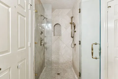 a bathroom with a granite countertop sink a large mirror and a shower