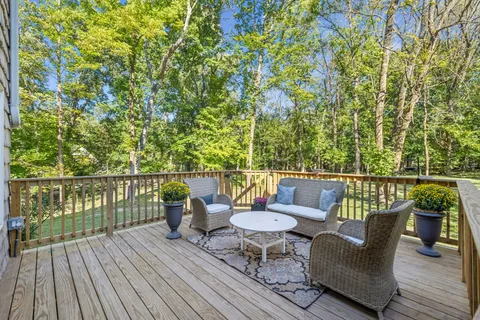 an empty room with a chandelier fan and windows