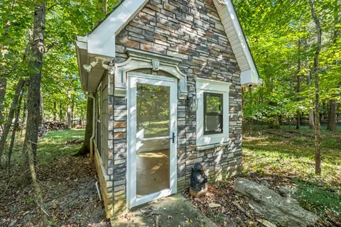 a view of a house with a big yard and large trees