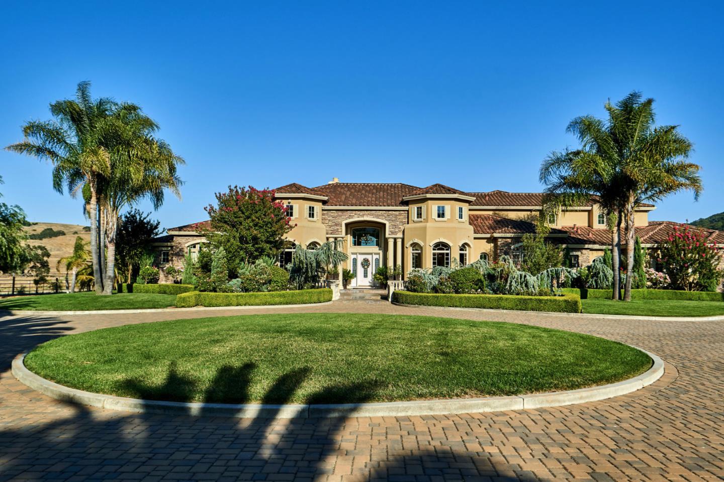 a view of a white house with a big yard and potted plants