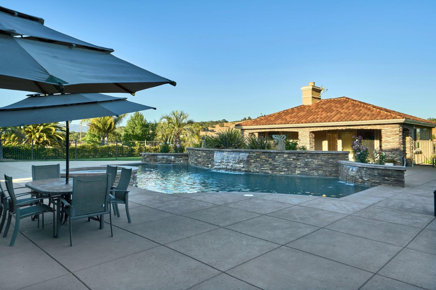 13800 Watsonville Road Morgan Hill, CA 95037 - Photo 60 of 74 a patio with a table and chairs under an umbrella