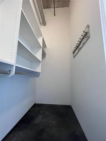a view of walk in closet with empty racks