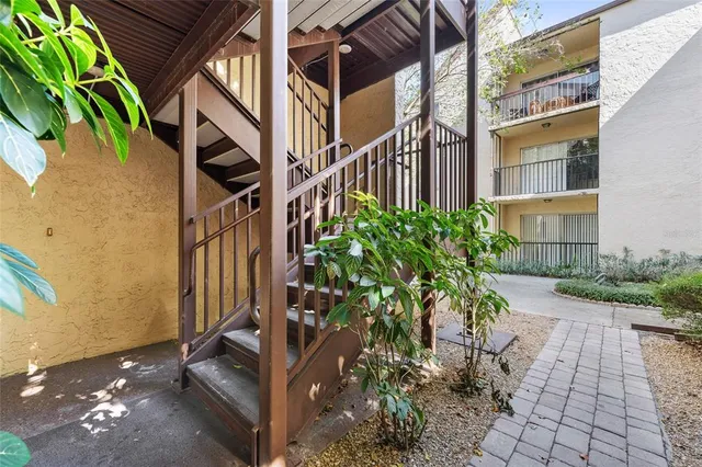 a view of a pathway of a house with potted plants