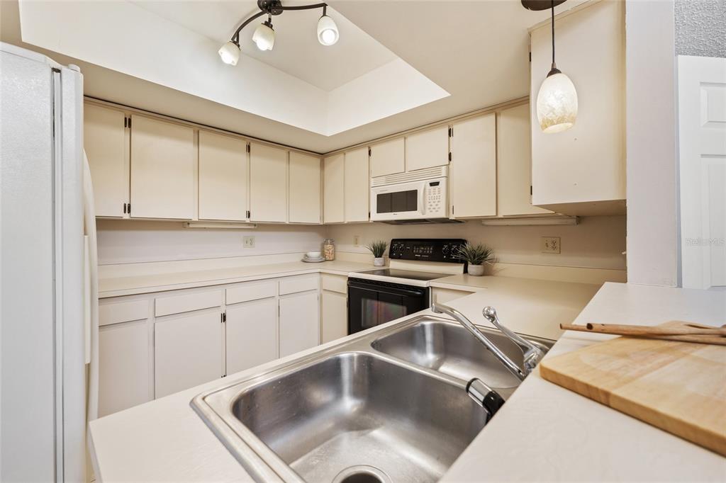2025 Sylvester Road, Unit N312 Lakeland, FL 33803 - Photo 11 of 35 a kitchen with stainless steel appliances a white stove top oven cabinets a sink and a counter space