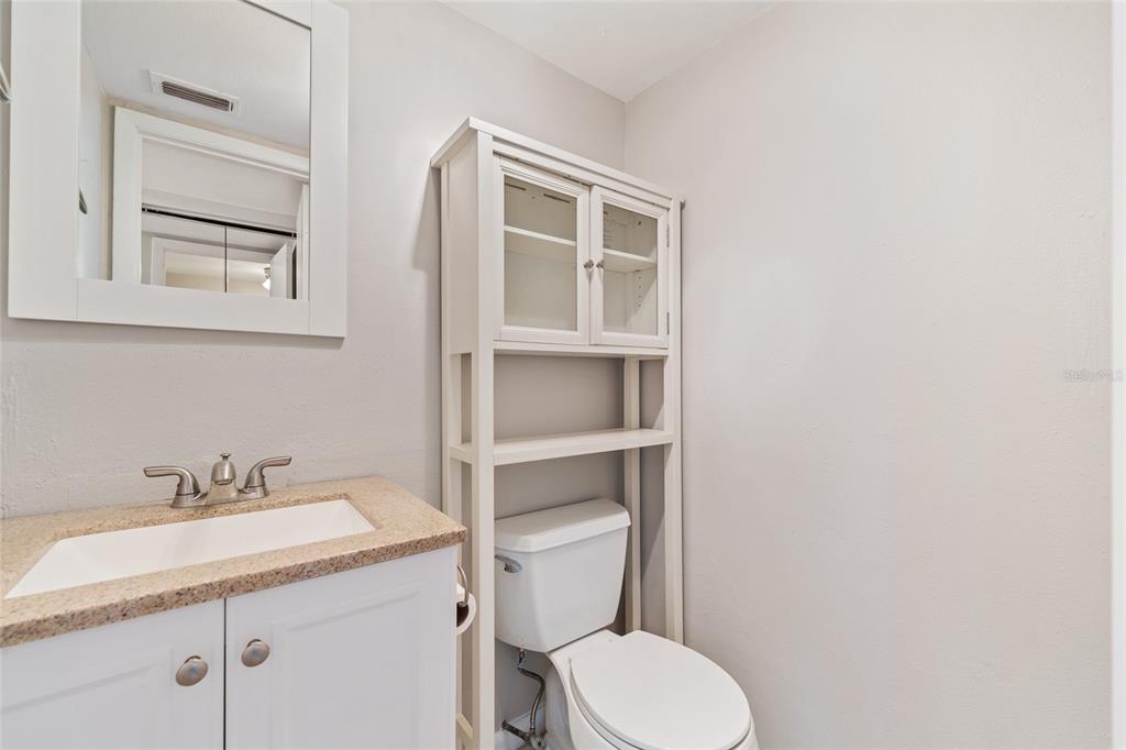 2025 Sylvester Road, Unit N312 Lakeland, FL 33803 - Photo 16 of 35 a bathroom with a granite countertop toilet sink and mirror