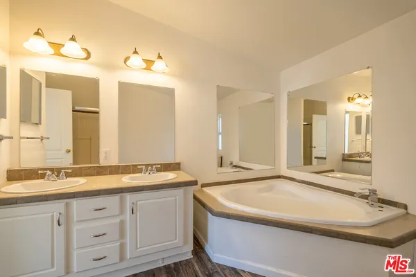 a bathroom with a tub sink and mirror