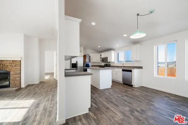 a view of kitchen with sink microwave refrigerator and cabinets