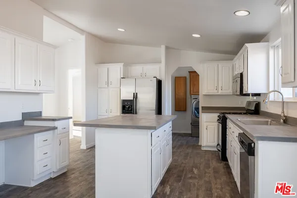 a kitchen with white cabinets stainless steel appliances and sink