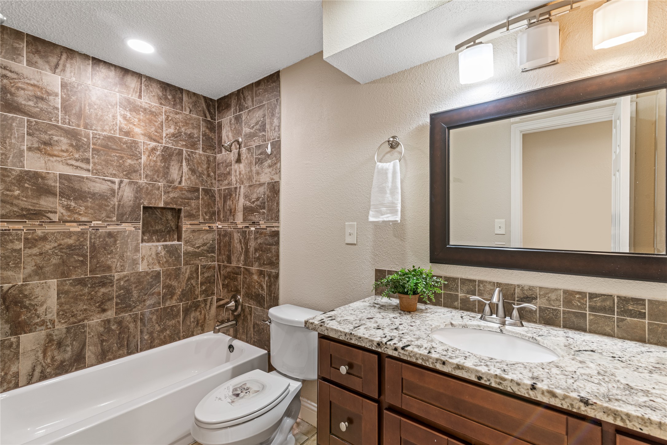 16027 Barbara Lane Magnolia, TX 77355 - Photo 16 of 40 a bathroom with a granite countertop sink a toilet a mirror a bathtub and shower