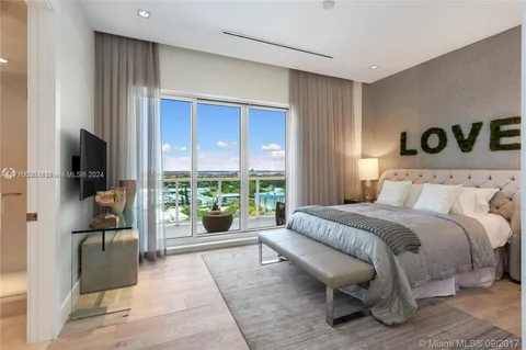 a spacious bedroom with a bed and glass window